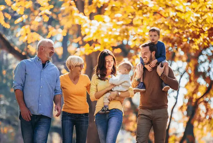 A group of people walking in the park with trees