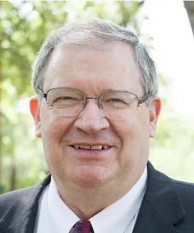 A man with glasses and a suit on.